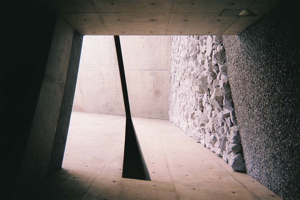 Picture of stone walls and concrete walls, part of Tadao Ando's minimalist architectural project at the Chichu Art Museum on Naoshima Island