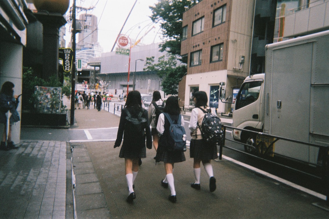 Picture of three schoolgirls in traditional uniforms walking in Tokyo