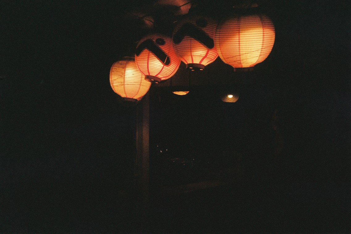 Picture of four lit lanterns in the dark in Kyoto